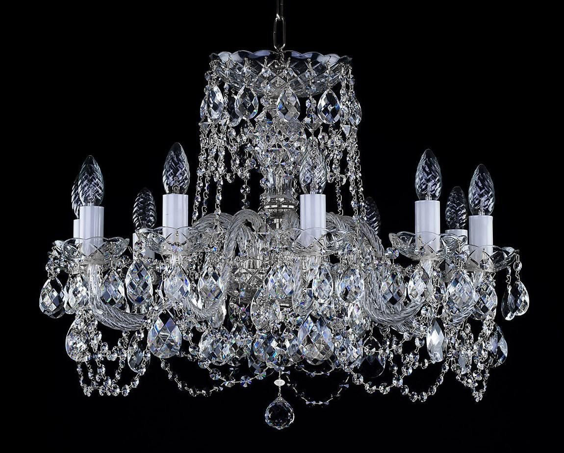 Vue frontale du même lustre, symétrie des bras et cristaux taillés sur fond noir.