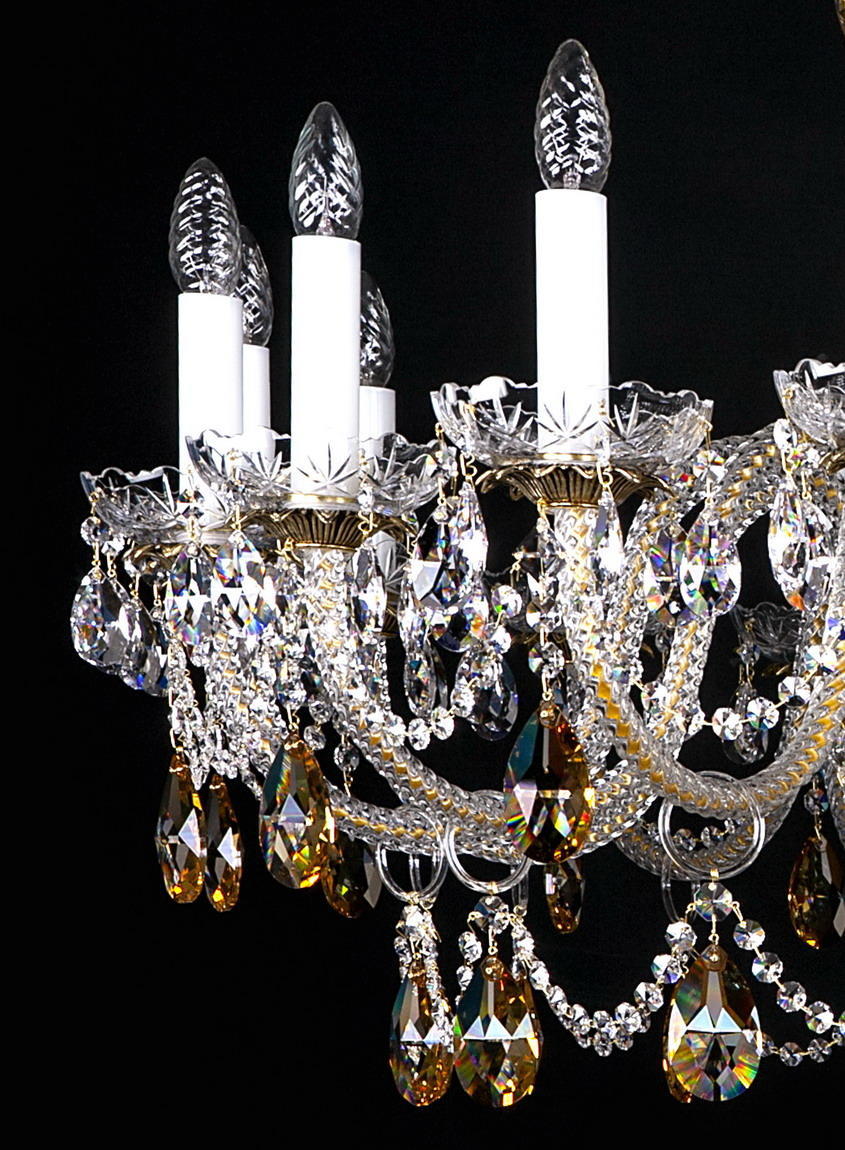 Détail des bougies blanches, bobèches dorées et grappes de cristal suspendues.