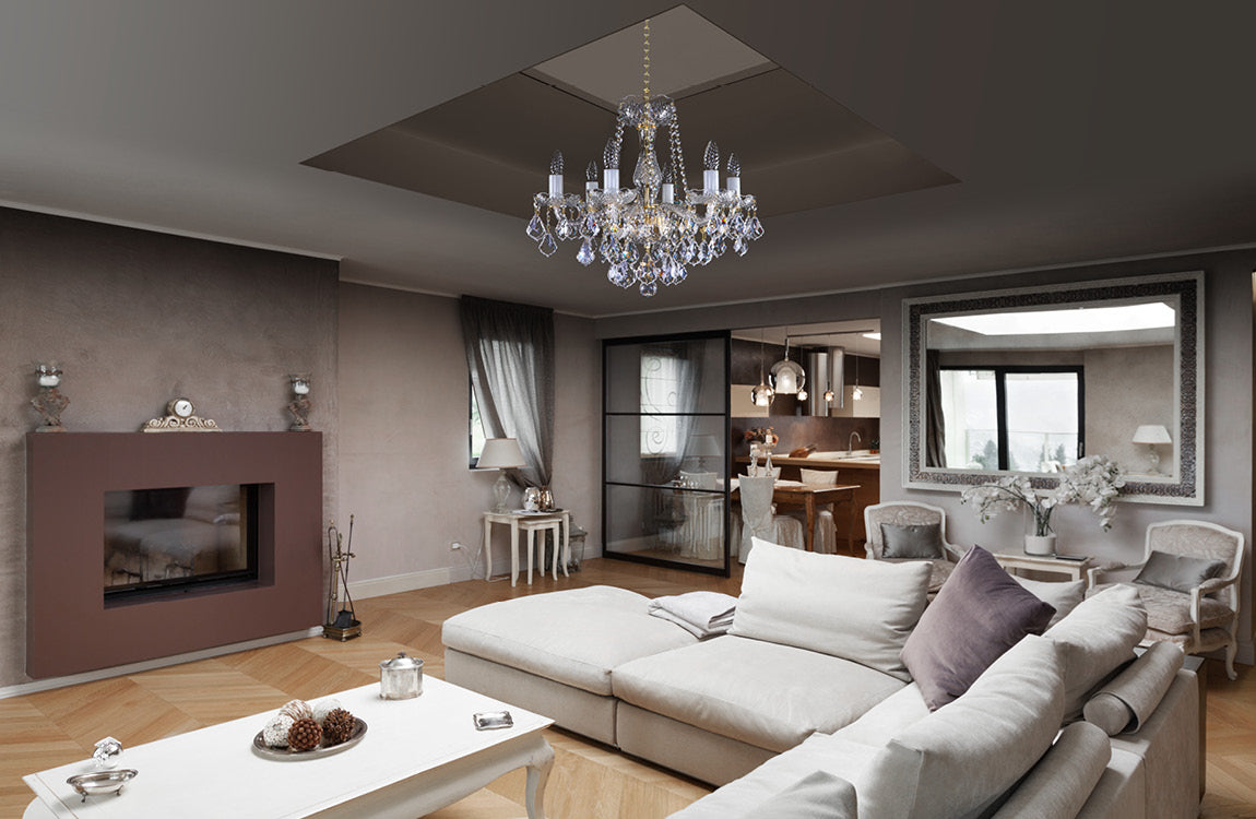 Lustre en cristal installé au plafond d'un salon moderne, au-dessus du canapé.