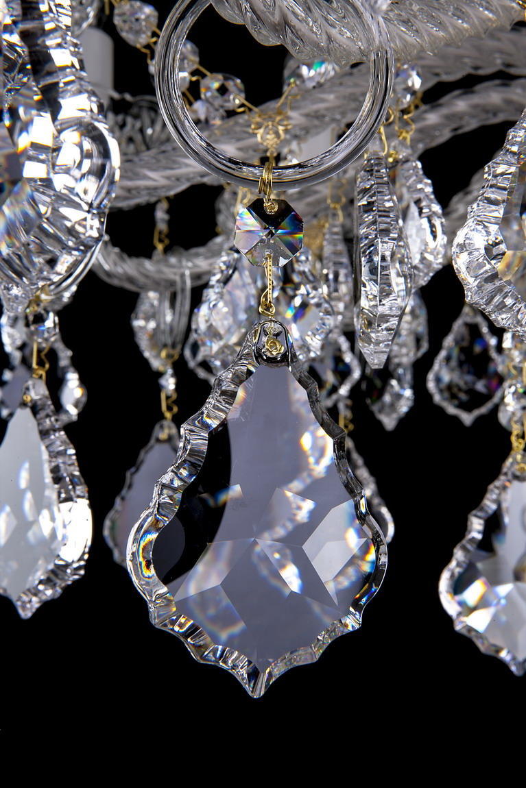 Gros plan sur une pampille de cristal taillé suspendue à un anneau doré.