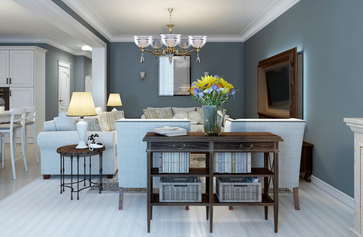 Lustre allumé au-dessus d'un salon bleu-gris avec meubles et bouquet coloré