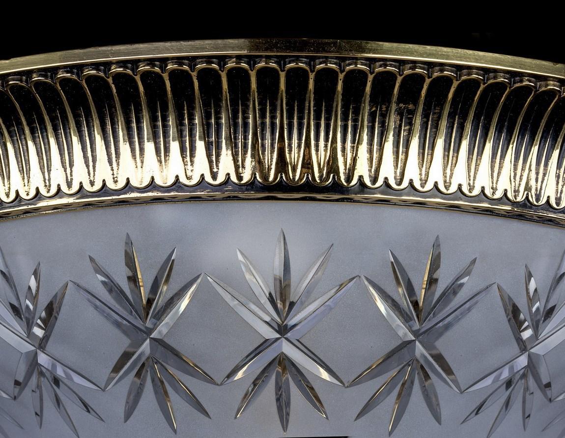 Gros plan sur la bague métallique dorée striée et le verre taillé