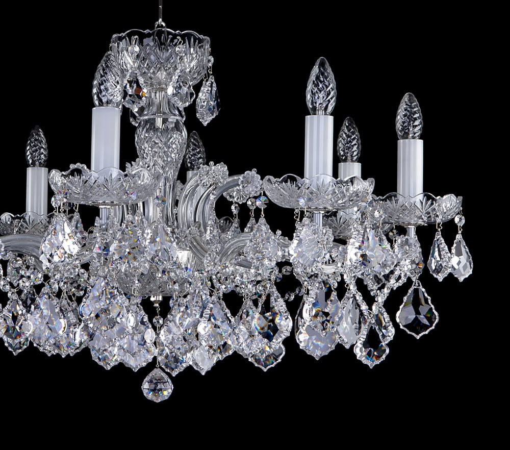 Détail du lustre : bras, bobèches et grappes de cristal taillé en gros plan.