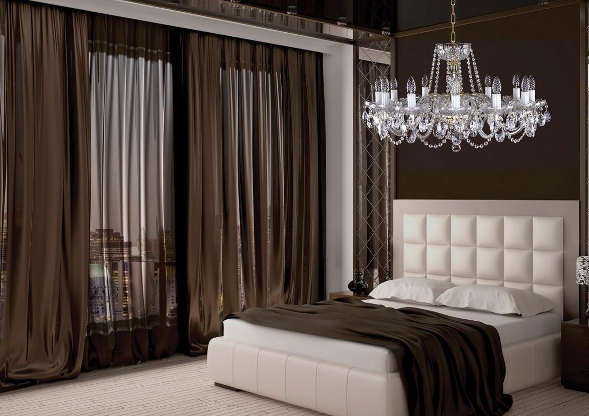 Mise en ambiance d'une chambre sombre, lustre suspendu au-dessus d'un lit blanc