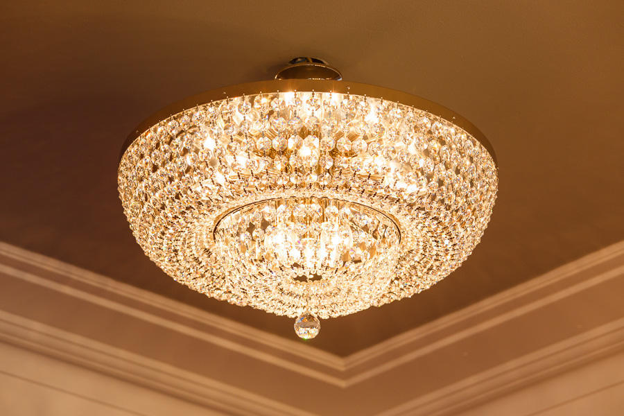 Vue en plongée du plafonnier allumé, lumière chaude et dorée près du plafond.