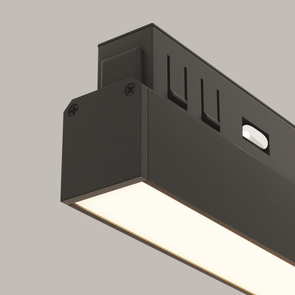 Gros plan sur l'angle du luminaire noir et sa surface texturée, diffuseur allumé.