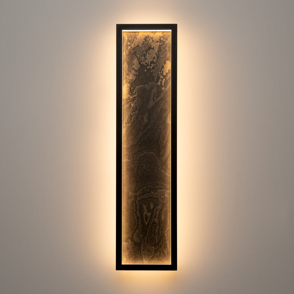 Applique allumée de face sur mur clair, halo lumineux chaud tout autour