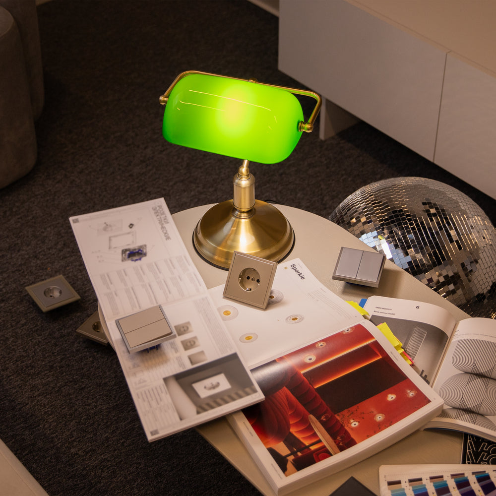 Mise en ambiance de la lampe posée sur une table avec catalogues et boule à facettes
