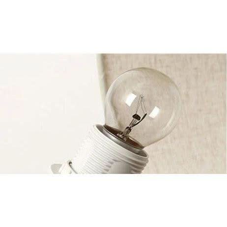 Détail de l'ampoule à filament vissée sur la douille en céramique blanche