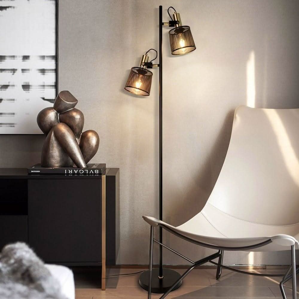 Les deux têtes du lampadaire éclairent une sculpture en bronze et un siège blanc