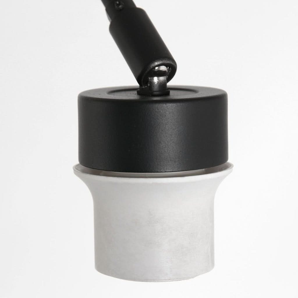Gros plan sur la douille blanche et l'articulation noire reliant le bras au luminaire