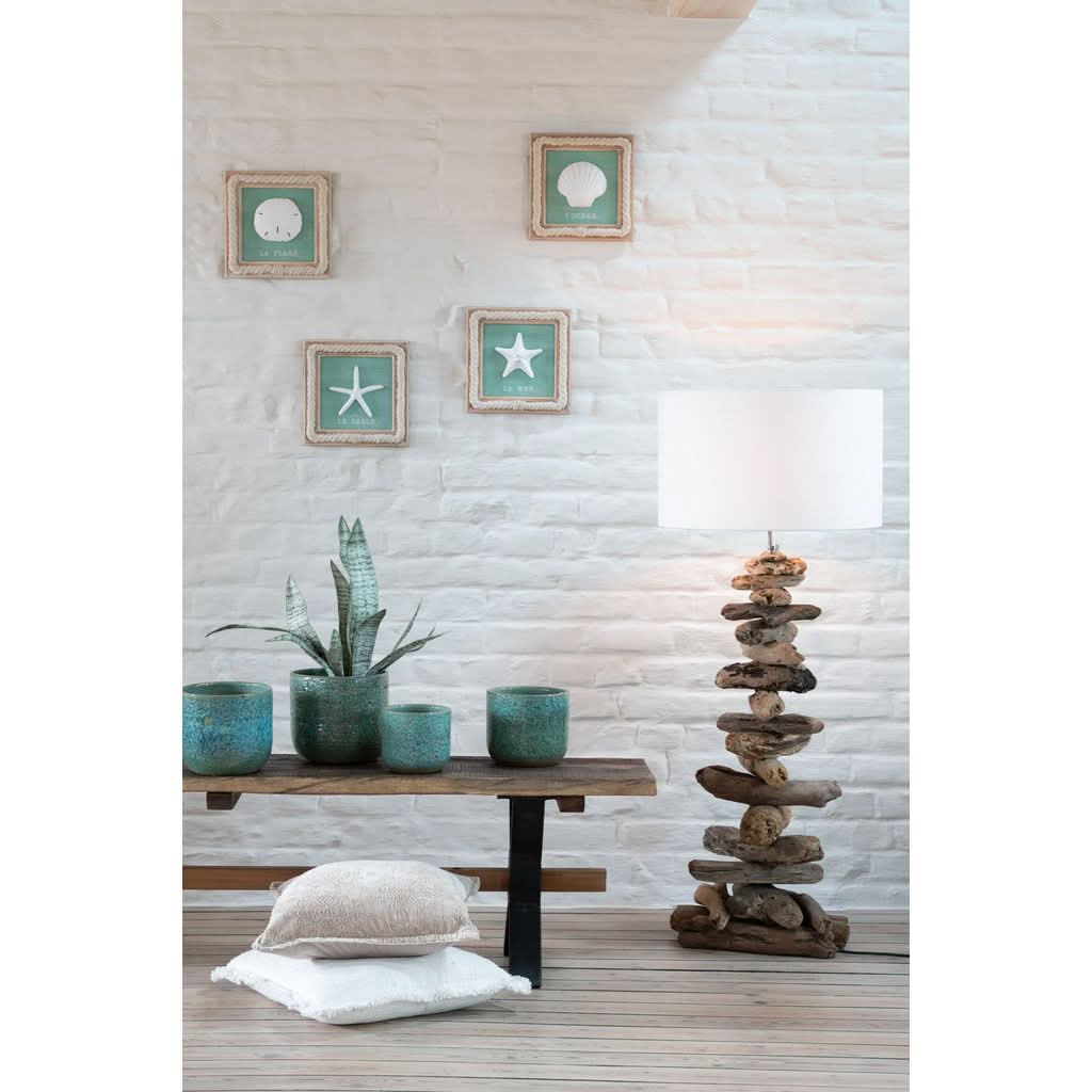Scène d'intérieur avec lampe près d'un banc, pots et coussins.
