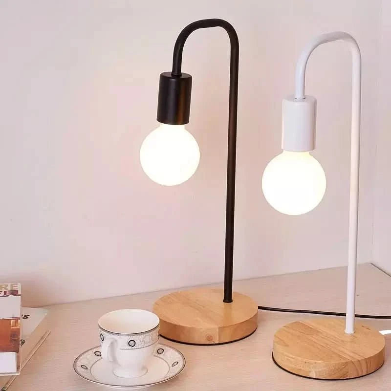 Deux lampes identiques, une noire et une blanche, posées côte à côte sur un bureau