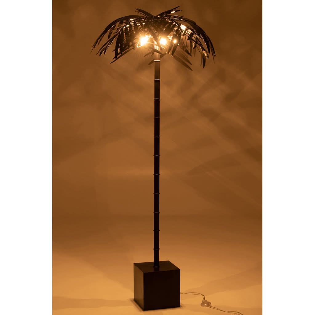 Lampe allumée dans un intérieur chaleureux, ombres portées sur mur ocre.