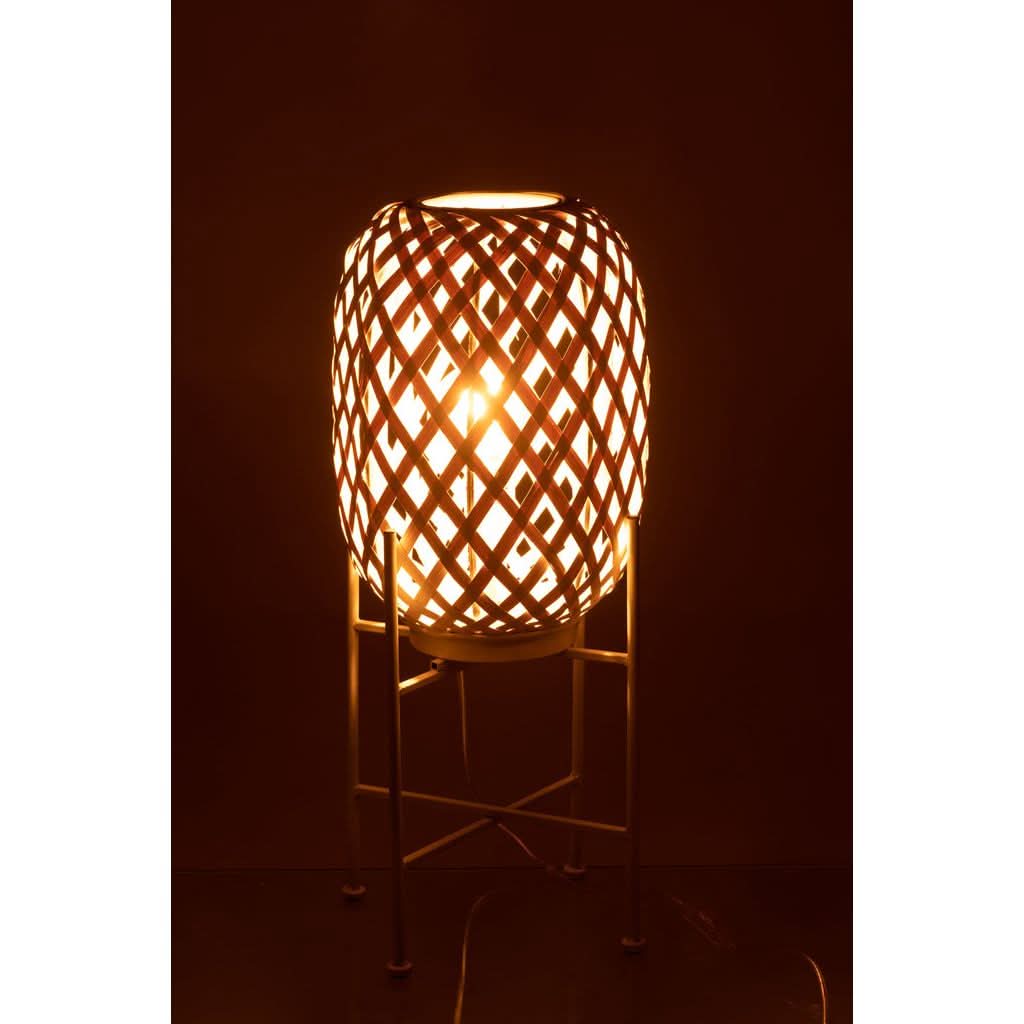Mise en ambiance nocturne, lampe allumée diffusant une lumière chaude à travers le bambou tressé.