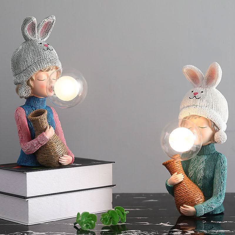 Deux variantes de la lampe à poser, éclairées, côte à côte sur fond gris