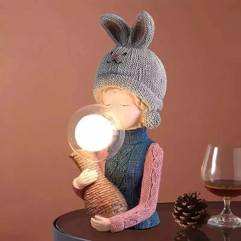 Gros plan de la lampe au bonnet gris, globe allumé, posée sur table en ambiance chaleureuse