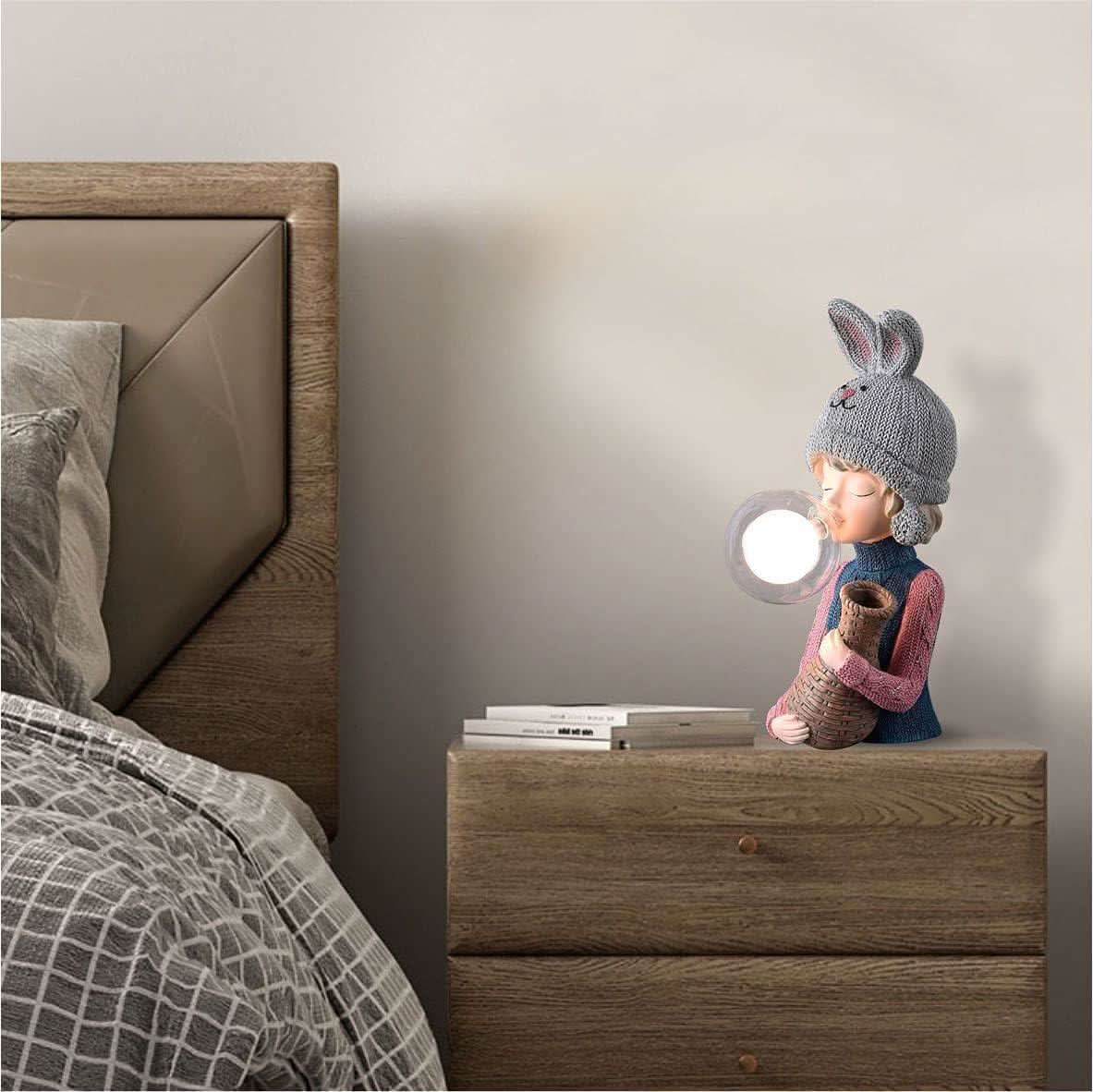 Mise en ambiance, lampe allumée posée sur table de nuit en bois près du lit
