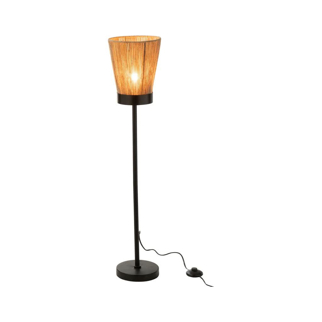 Lampadaire allumé, abat-jour en fibres tressées diffusant une lumière chaude.