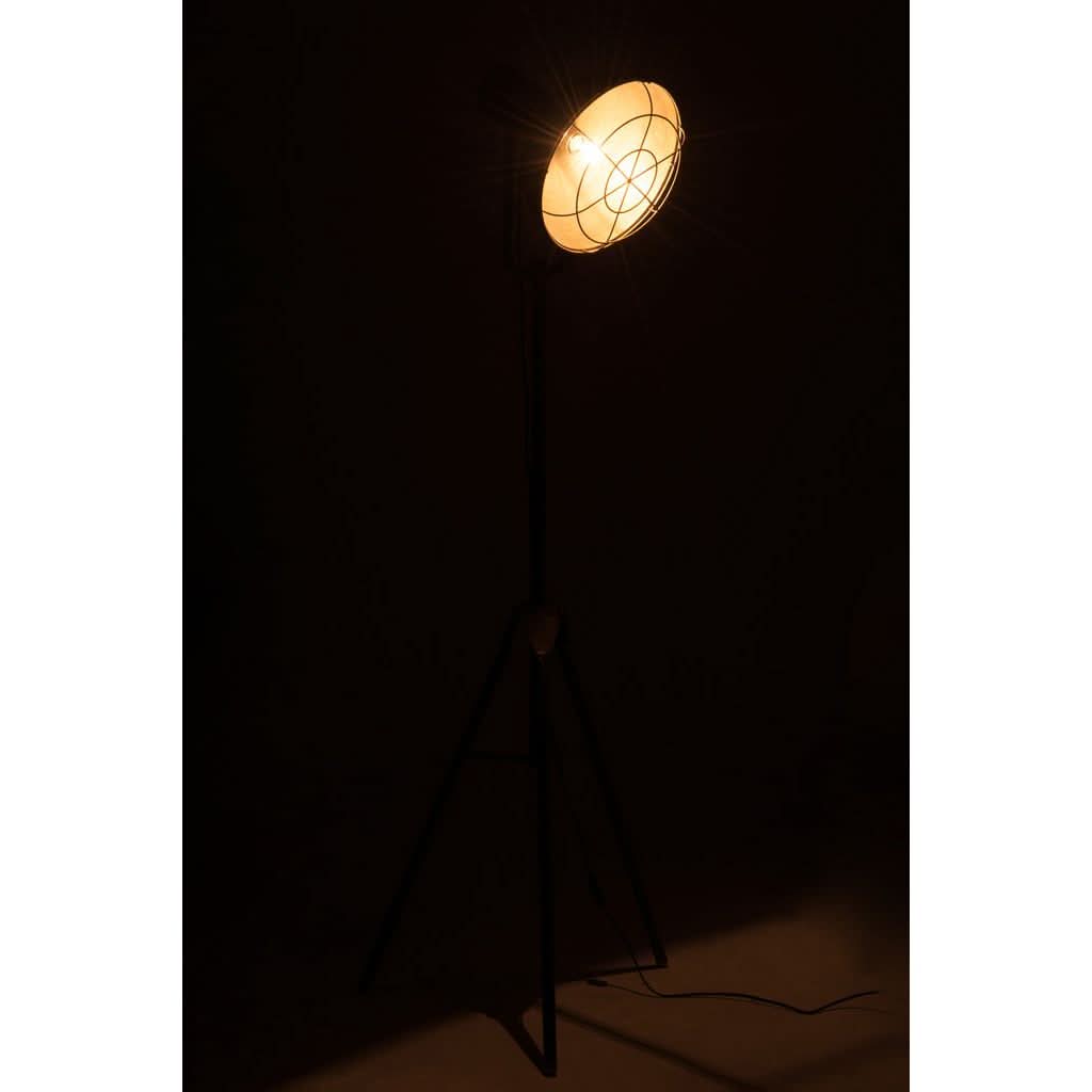 Lampe allumée dans une pièce sombre, diffusant une lumière chaude et projetant des ombres