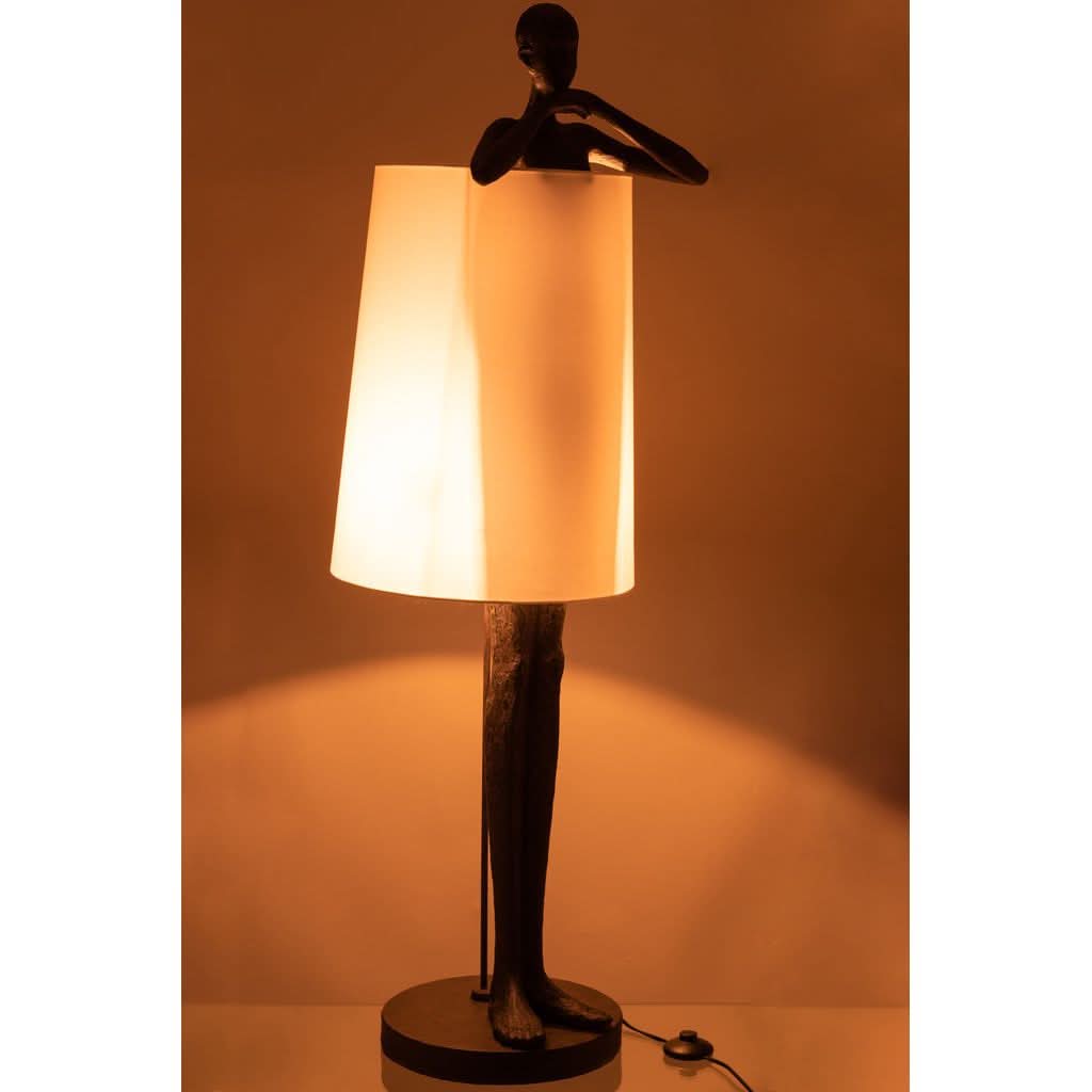 Lampe allumée dans une ambiance chaude, lumière orangée diffusée par l'abat-jour