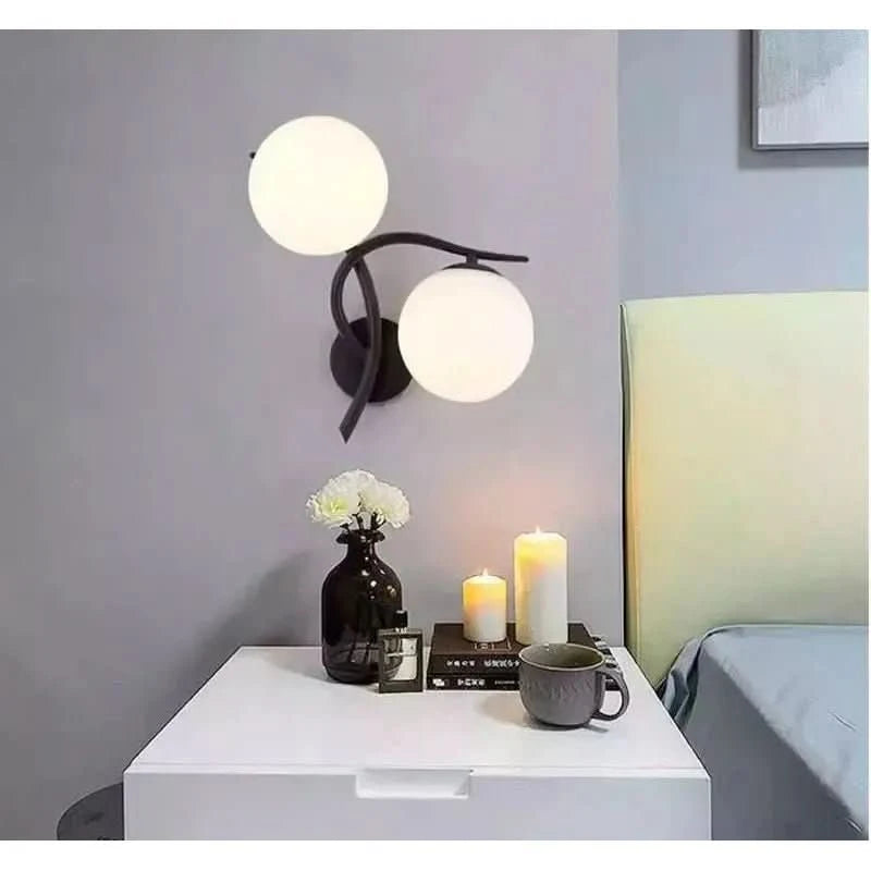Applique fixée au mur gris au-dessus d'une table de chevet avec bougies