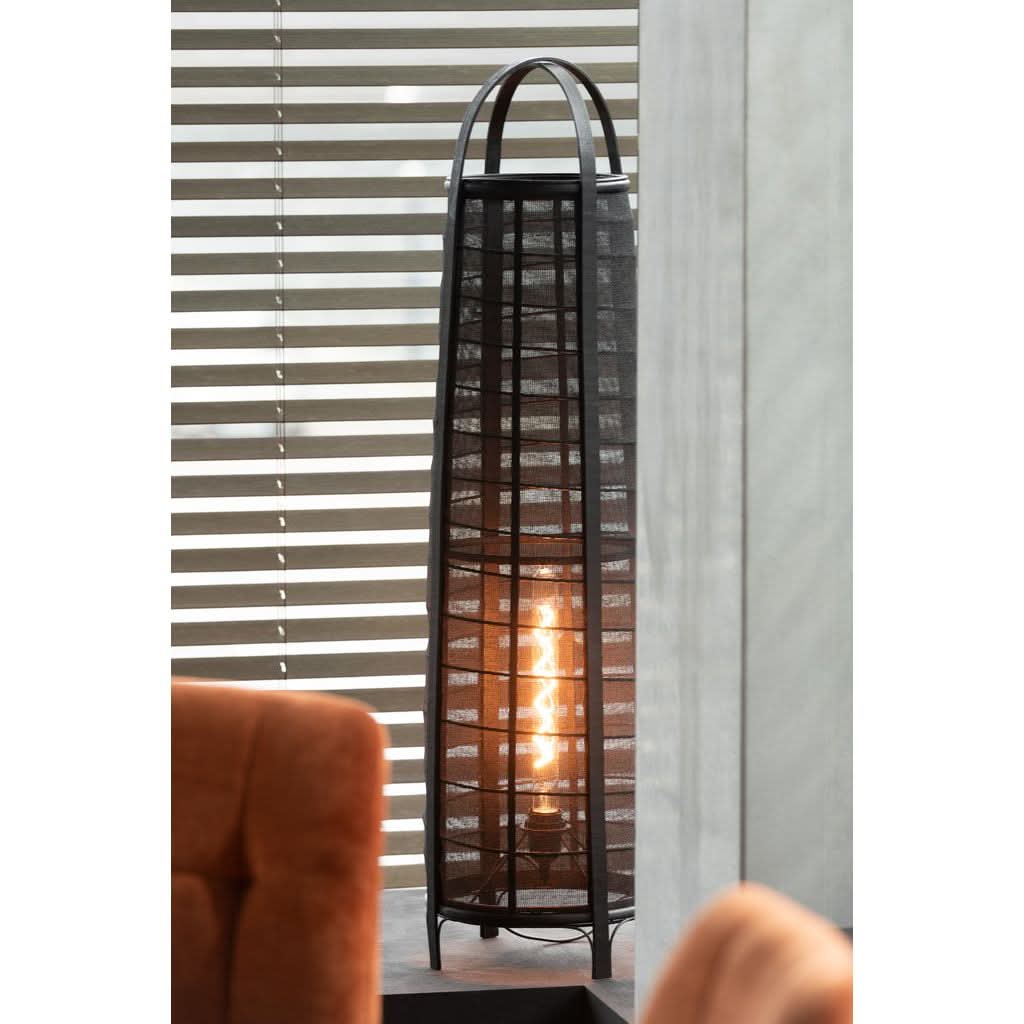 Lampe allumée près des stores, ambiance intérieure, fauteuil orange à gauche.