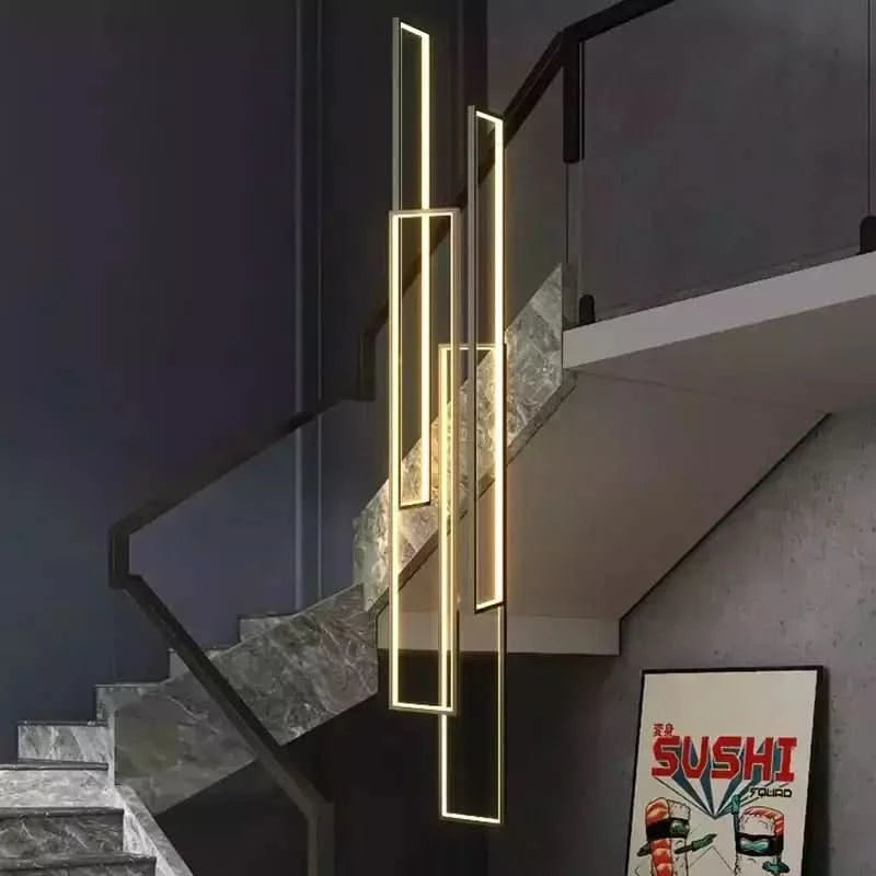 Suspension rectangulaire dorée lumineuse installée devant un escalier en pierre, vue d'ensemble.