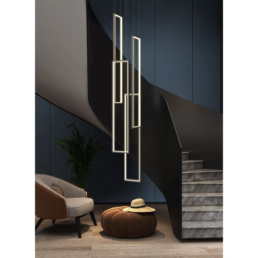 Mise en ambiance moderne avec la suspension dorée, un fauteuil et un pouf près d'un escalier.