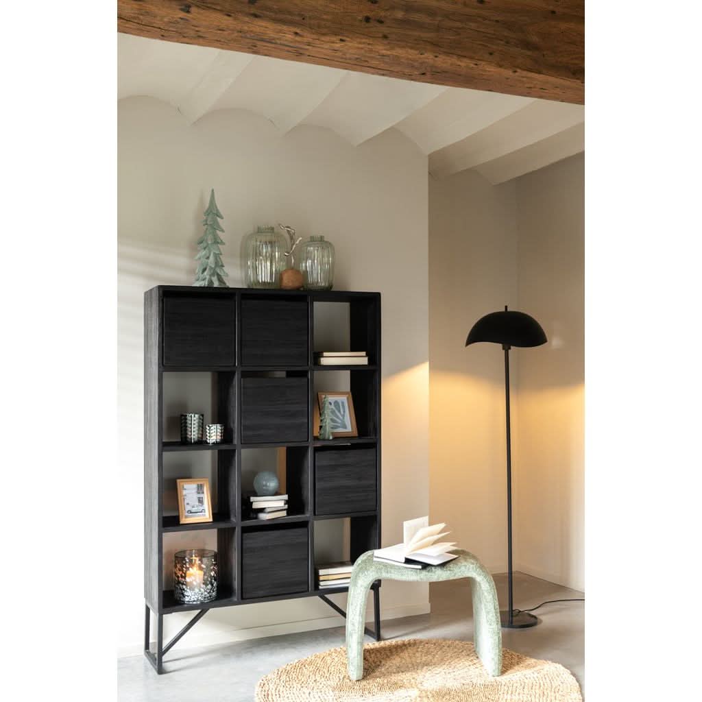 Lampe installée dans un salon, près d'une étagère noire, ambiance déco chaleureuse.