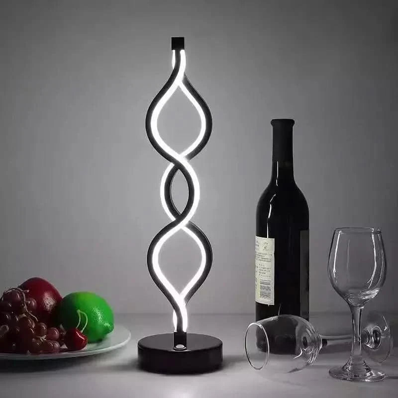 Version noire à double boucle torsadée posée près d'une bouteille de vin