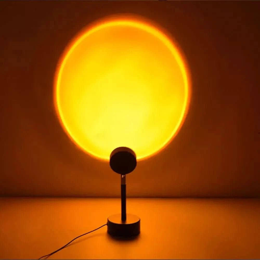 Mise en ambiance : grand halo orangé projeté sur un mur sombre, lampe posée au sol.