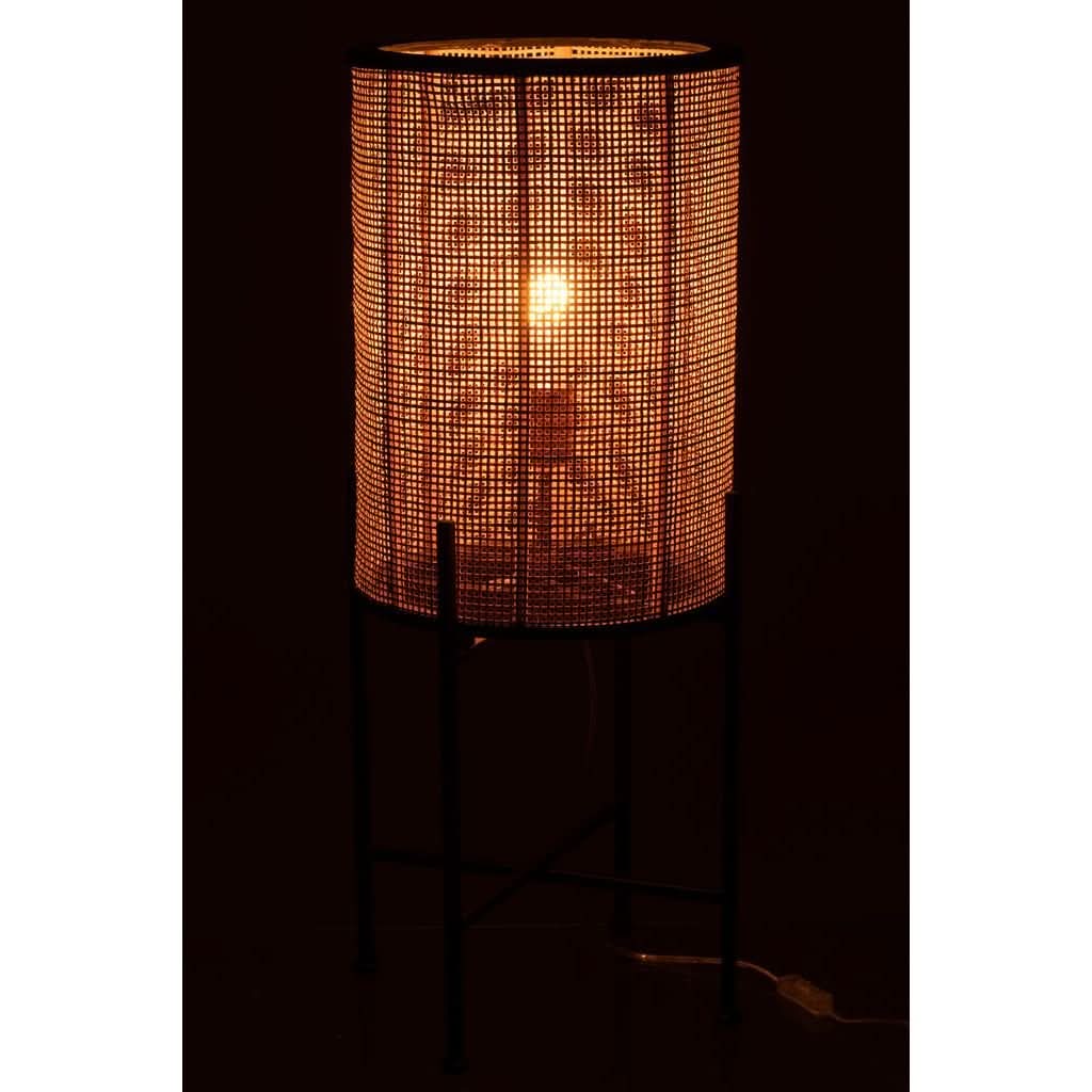 Mise en ambiance nocturne, lampe allumée diffusant une lumière chaude à travers l'abat-jour en cannage.