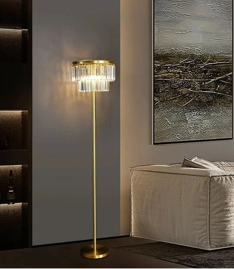 Lampadaire doré debout près d'un fauteuil gris et d'un tableau