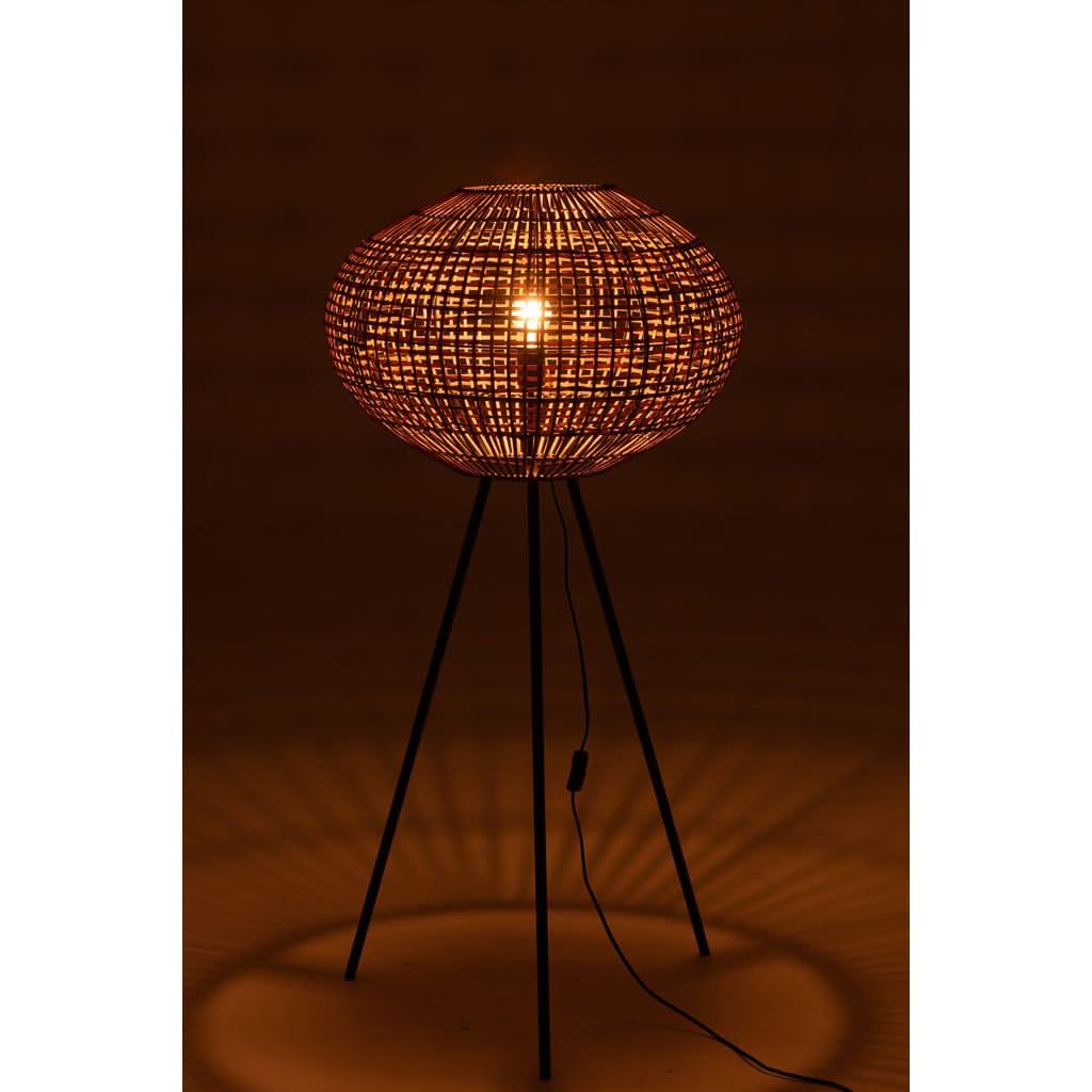 Lampe allumée dans la pénombre, halo chaud projeté au sol par le tressage