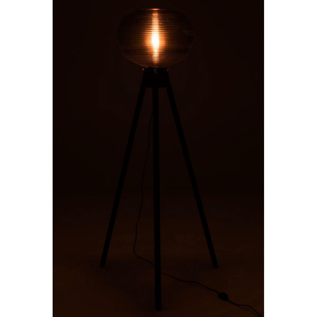 Lampe allumée dans une pièce sombre, halo orangé traversant l'abat-jour sphérique