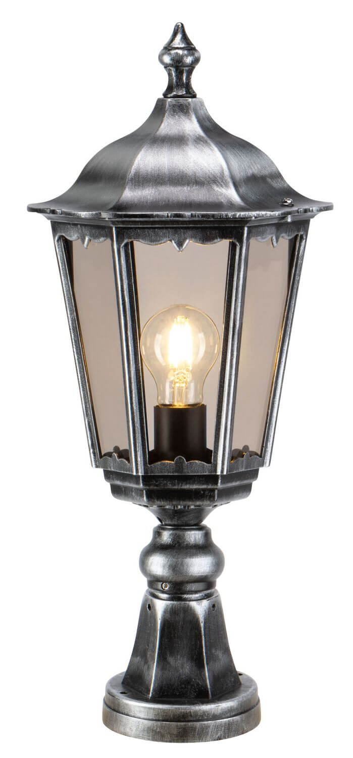 Luminaire extérieur allumé, ampoule à filament chaude éclairant la lanterne noire et argentée.
