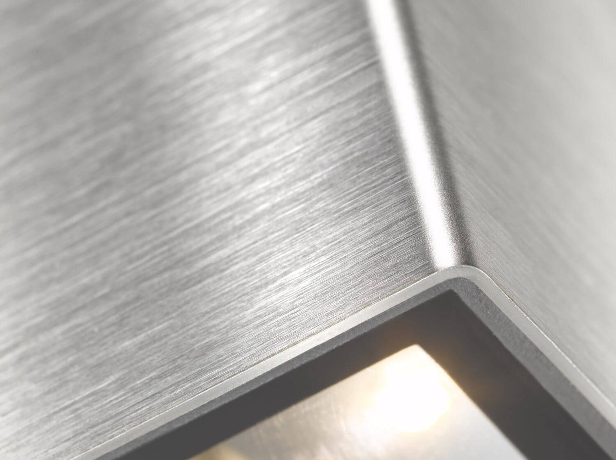 Gros plan sur la finition inox brossé et l'arête pliée du boîtier