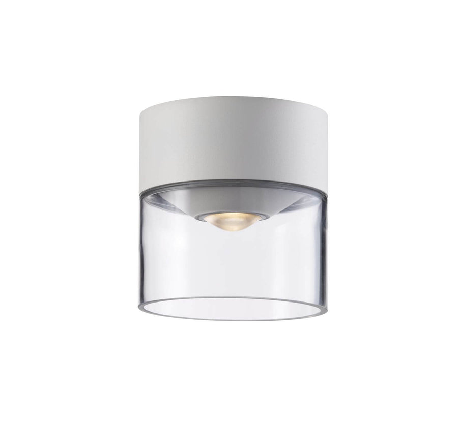 Plafonnier allumé, ampoule dorée visible sous le diffuseur en verre transparent