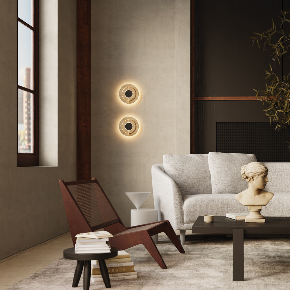 Mise en ambiance salon, deux appliques allumées sur un mur beige