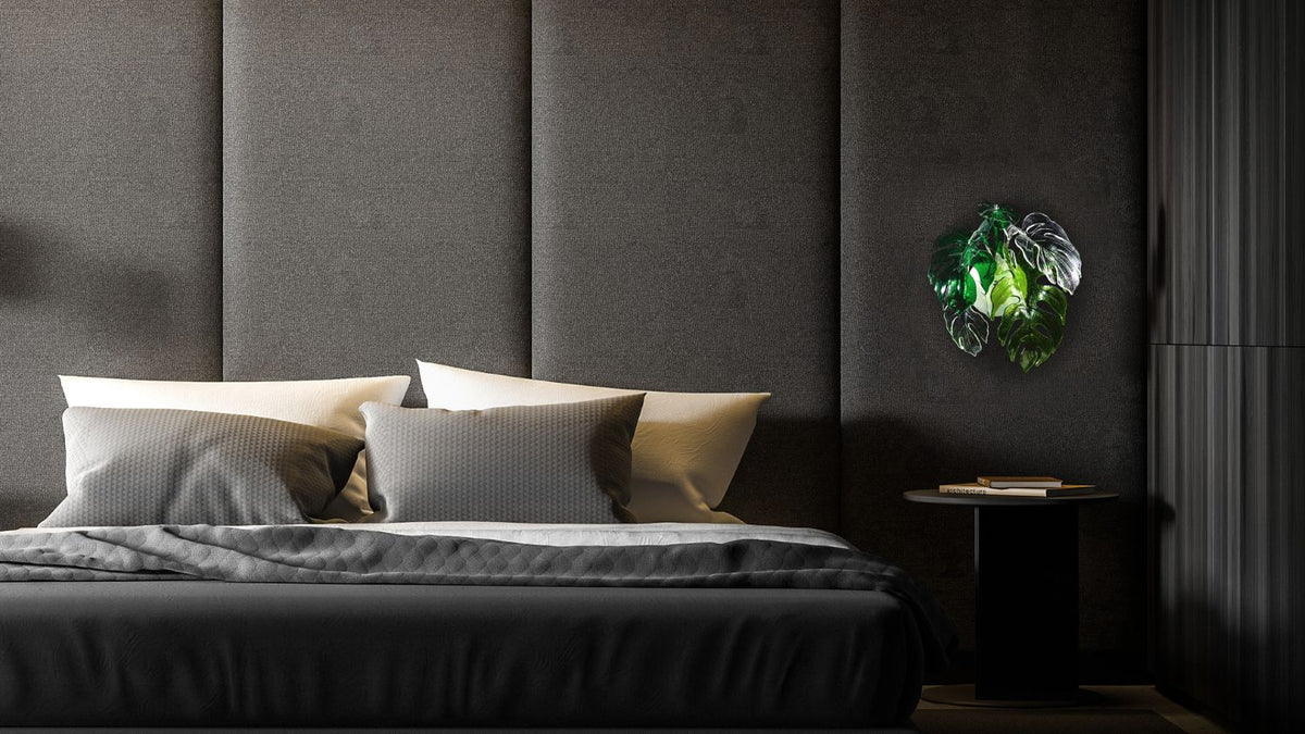 Applique verte allumée dans une chambre sombre, mur capitonné, ambiance feutrée du soir