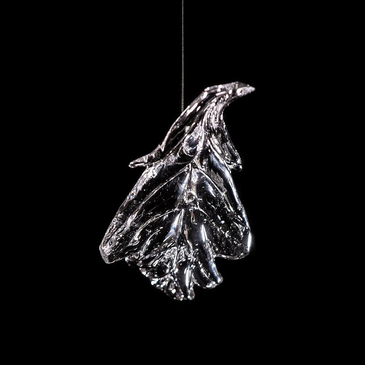 Détail d'une feuille de verre suspendue par câble fin, reflets lumineux
