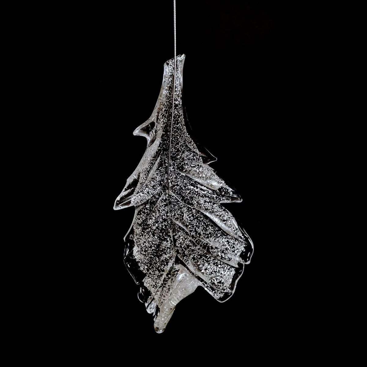Gros plan d'une feuille givrée suspendue, texture cristalline très marquée