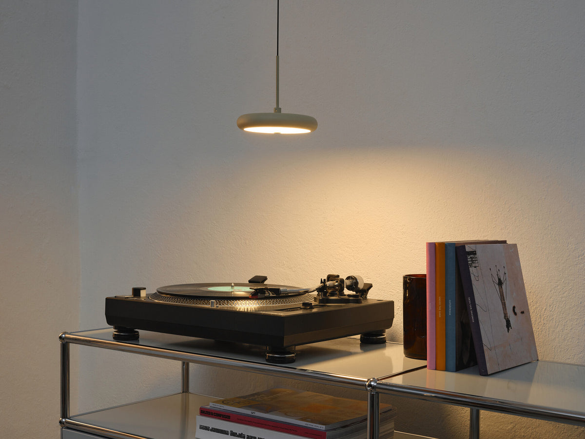 Mise en ambiance au-dessus d'une platine vinyle et de livres sur étagère.