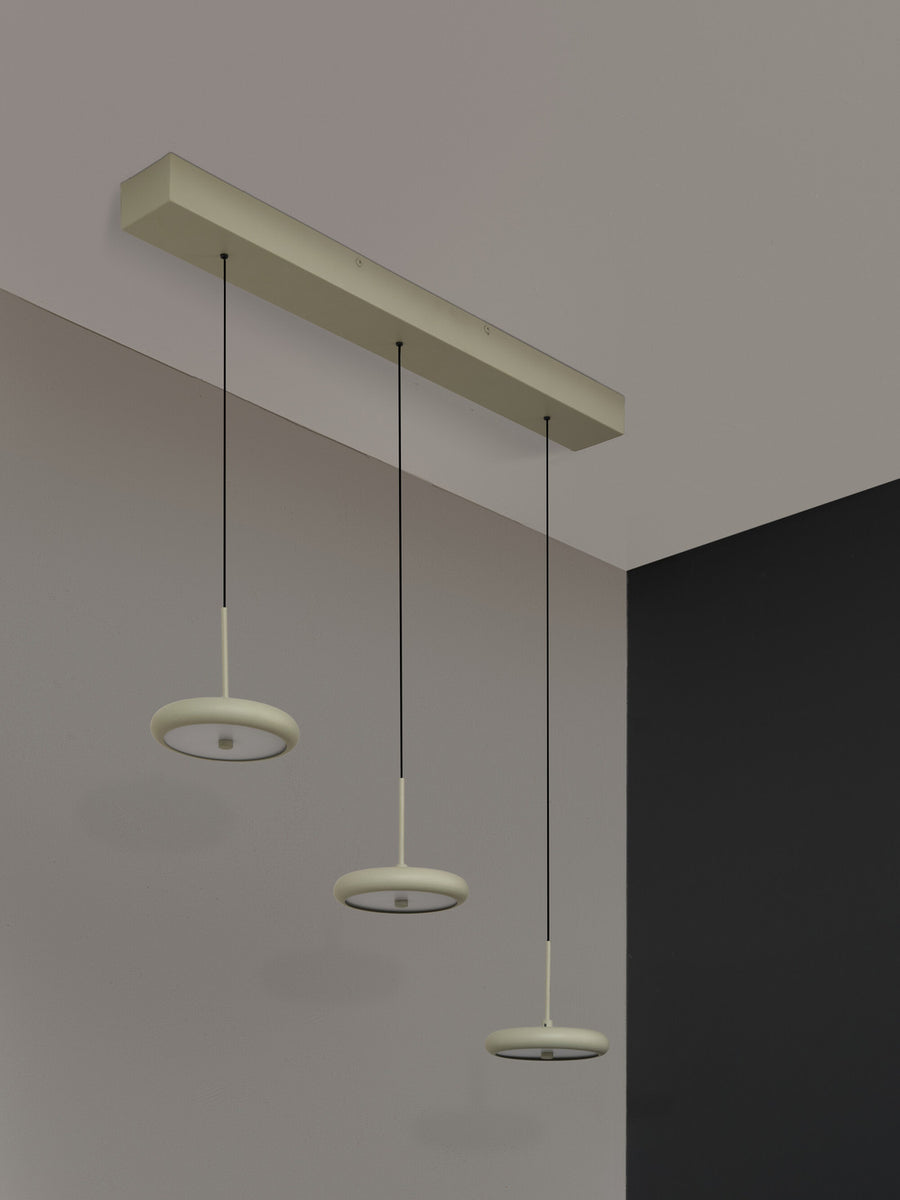 Vue en contre-plongée du rail de fixation et des trois câbles noirs suspendus.