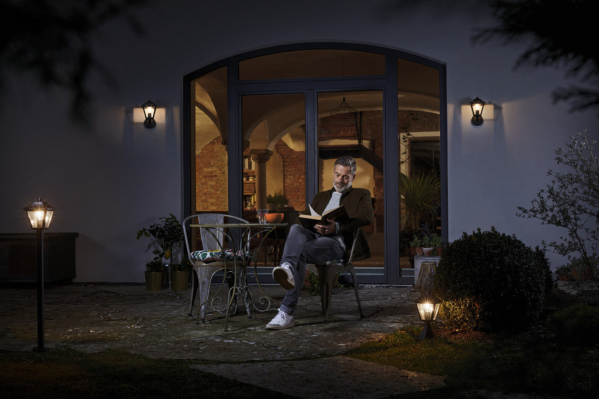 Mise en ambiance nocturne d'une terrasse, appliques murales éclairant la façade et le salon