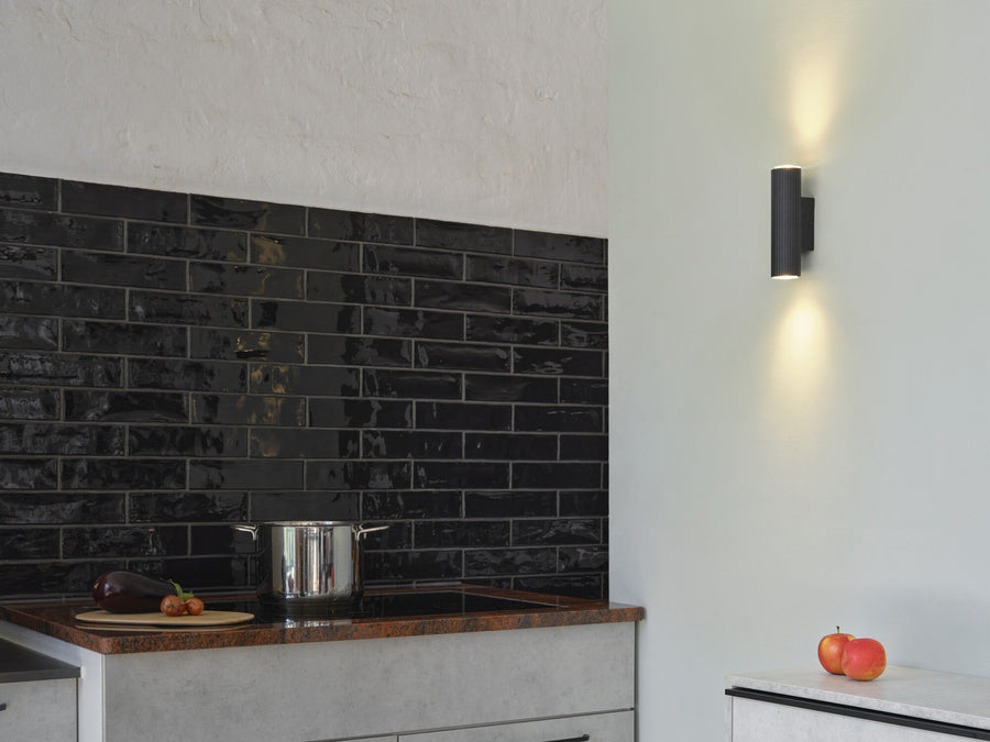 Applique noire installée dans une cuisine, éclairant mur et crédence noire