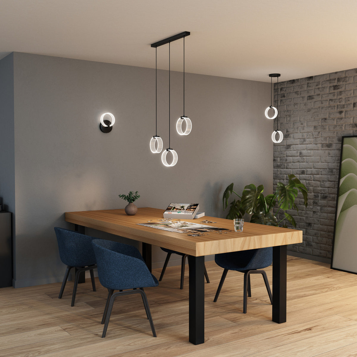 Puzzle étalé sous la suspension à trois anneaux, table en bois et mur de briques.