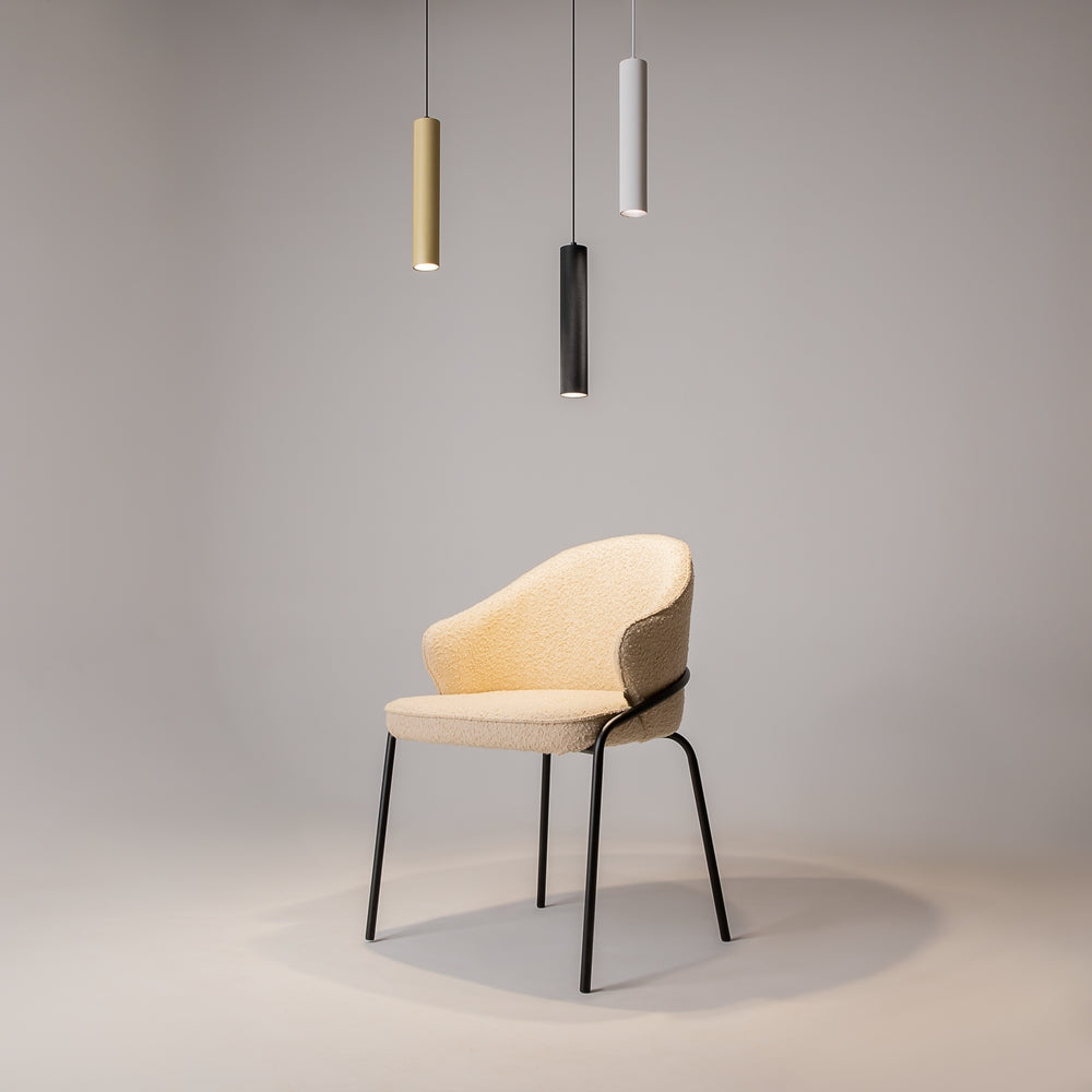 Trois suspensions de teintes différentes devant une chaise, ambiance décorative.