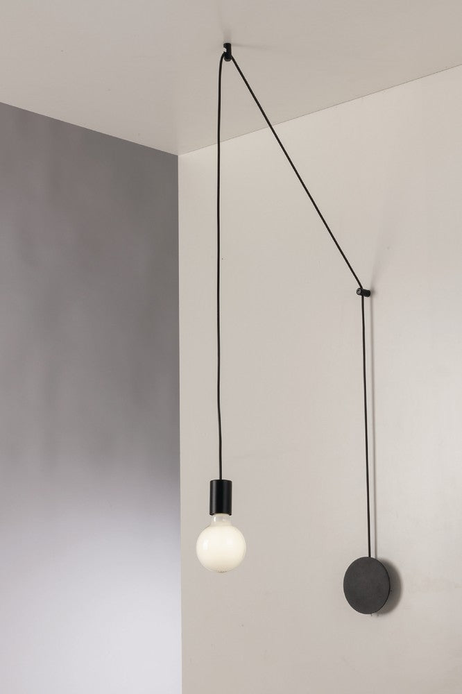 Détail de l'ampoule globe allumée et de la douille noire fixée au câble